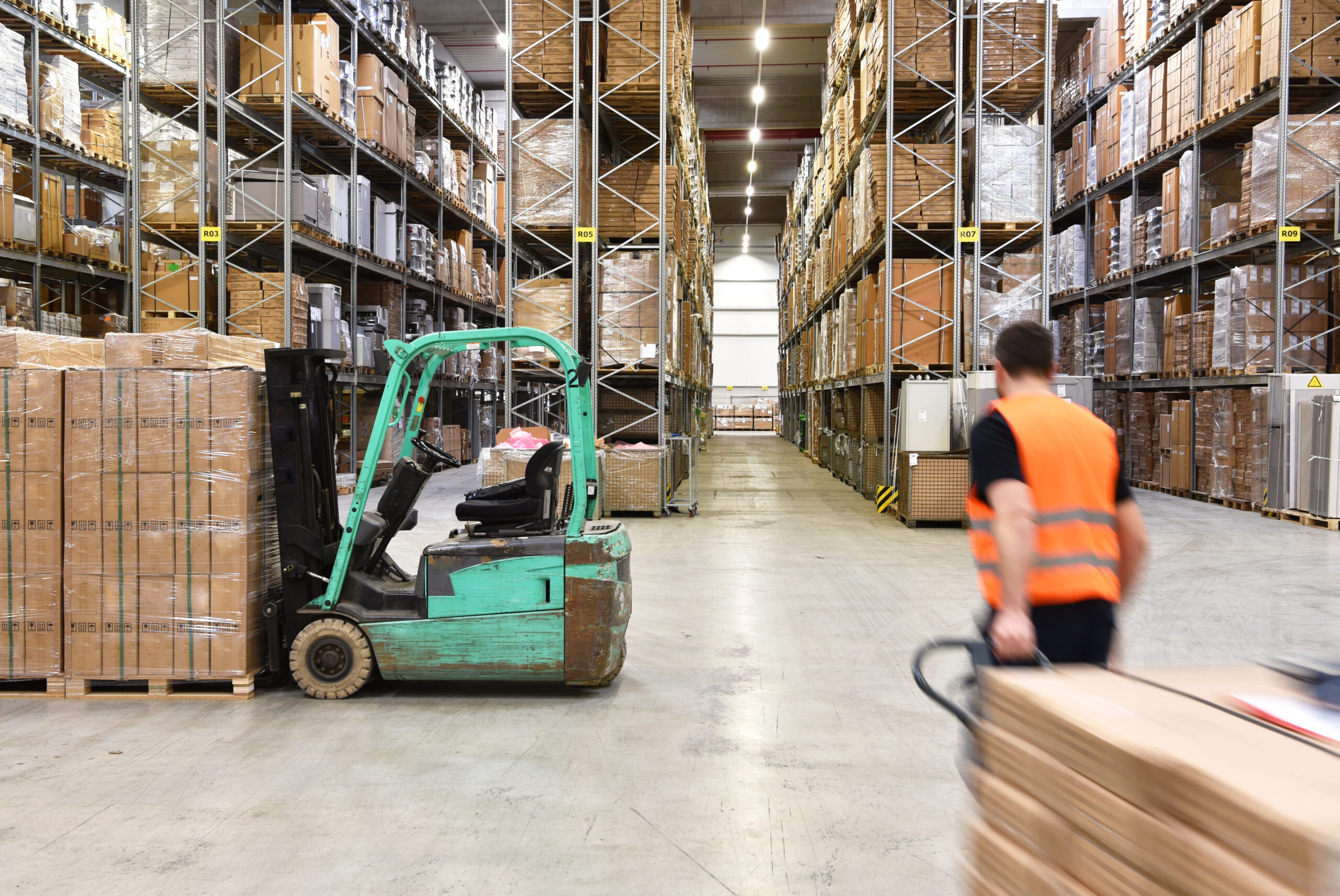 warehouse worker in a forwarding agency - interior with forklift - transport and storage of goods