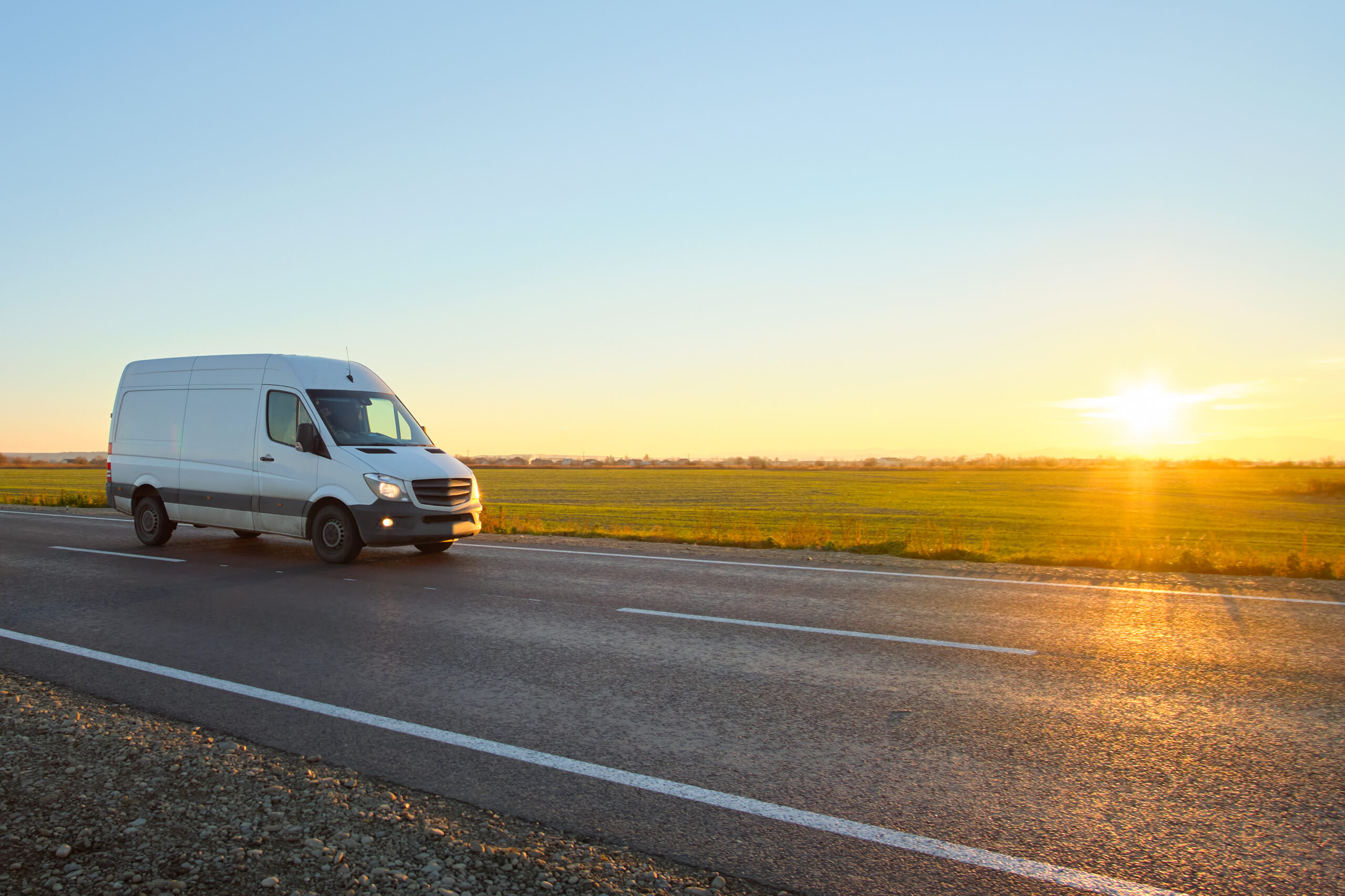 Small cargo van driving on highway hauling goods. Delivery transportation and logistics concept.
